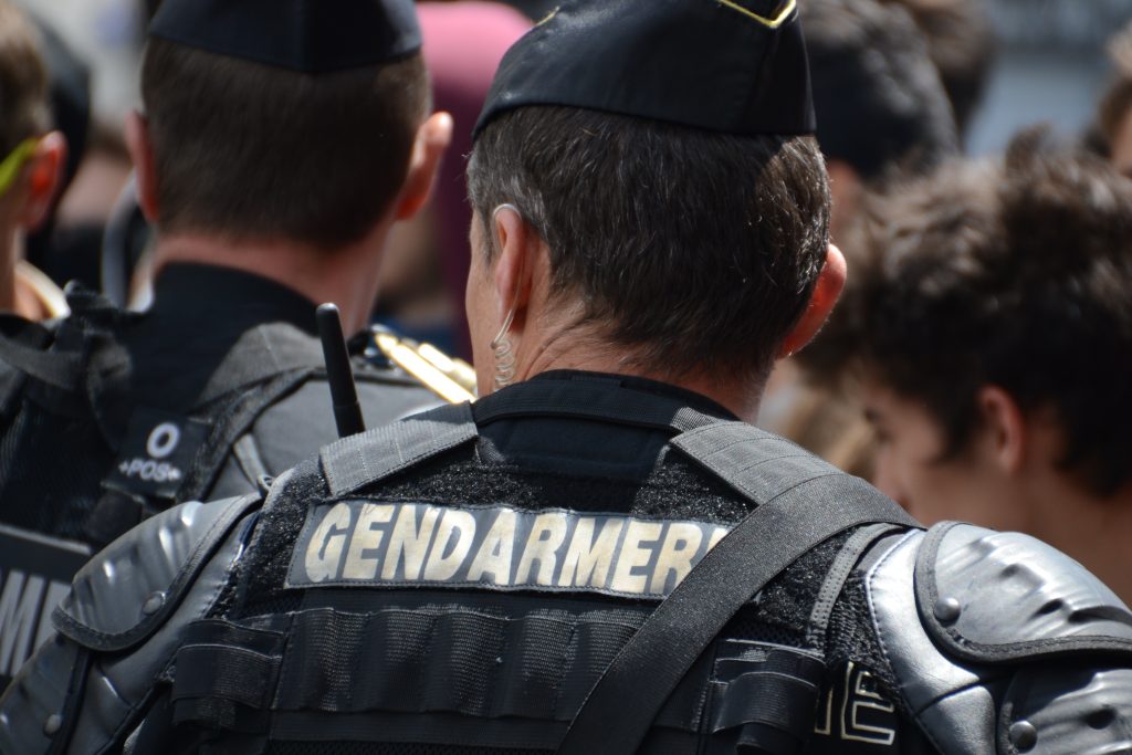 Gendarme en uniforme surveillant une foule.